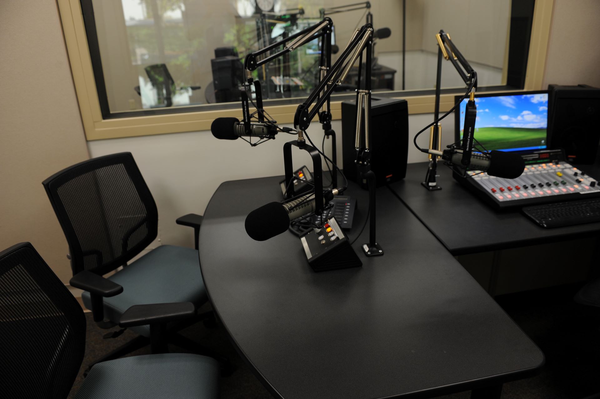 Inside the WFIT Broadcast Center at Florida Tech, showcasing the recording studio with microphones, mixing consoles, computer screens, and other audio equipment