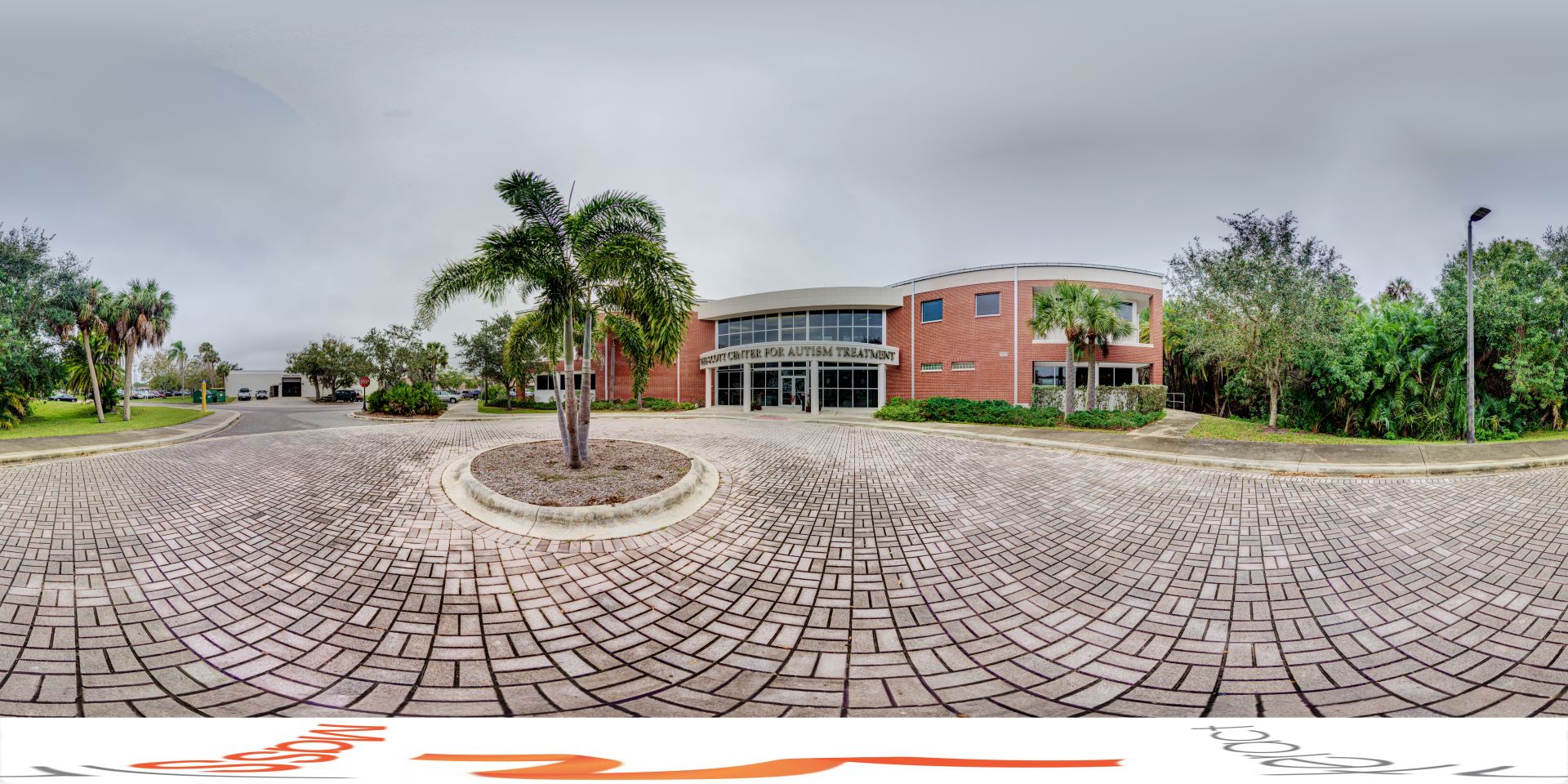 Panoramic view of the Scott Center for Autism Treatment, entrance to the building from the paved pathway